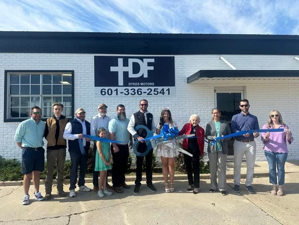Dykes Motors Power Equipment grand opening ribbon cutting in Collins, Mississippi — Casey Dykes, Everett Dykes, Charles Brooks, family, and Covington County Chamber of Commerce